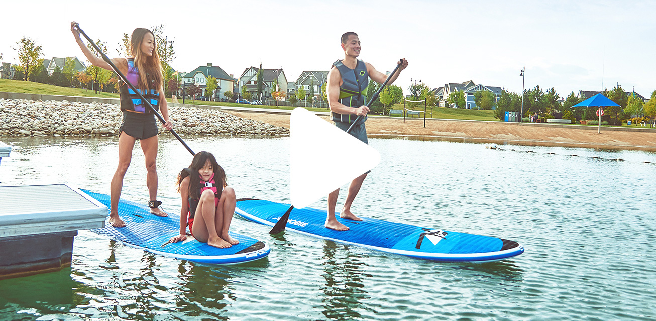 Couple paddleboarding with child