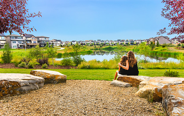 Woman with arms around her young daughter looking out at wetland area